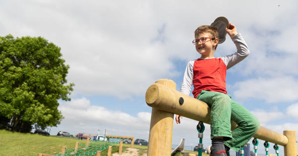 Child sitting on top of play equipment