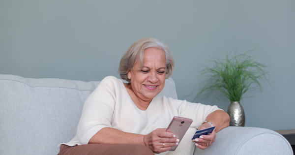 senior woman paying bill on phone