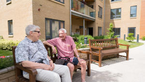 two men sat on bench outside their homes