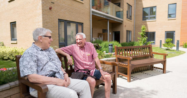 two men sat on bench outside their homes