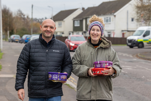 Man and woman walk along holding hampers