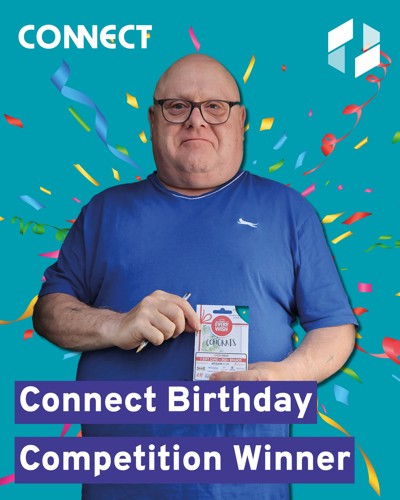 Man holding prize voucher with confetti in the background.