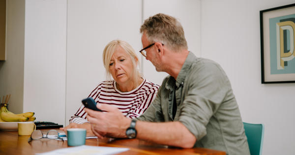 man and woman looking at phone