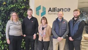 Four people standing in Alliance Homes reception