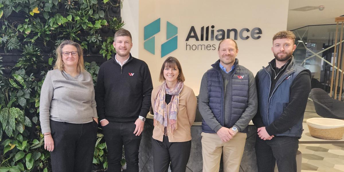 Four people standing in Alliance Homes reception