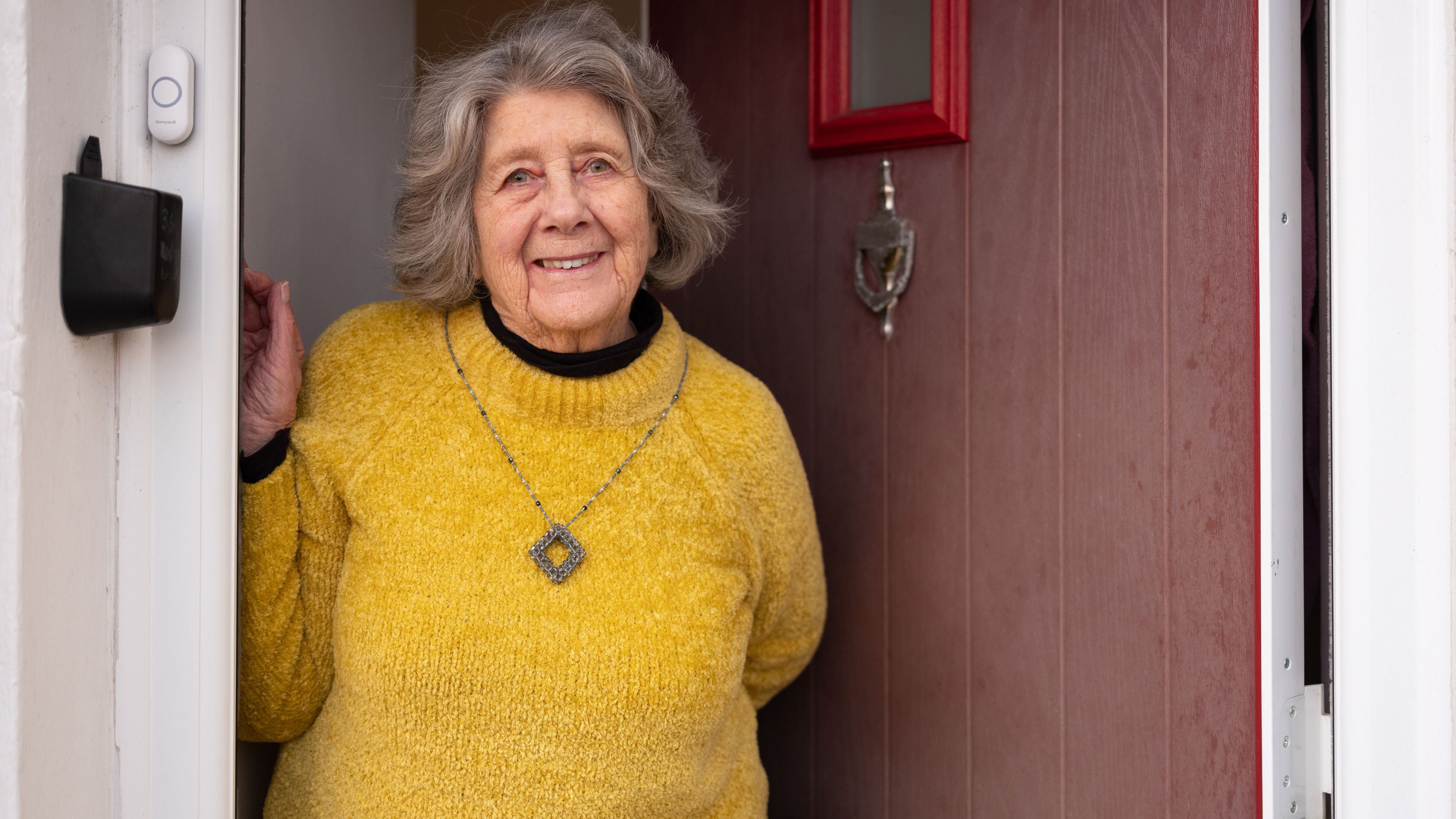 Elderly Woman Standing In Her Door Way