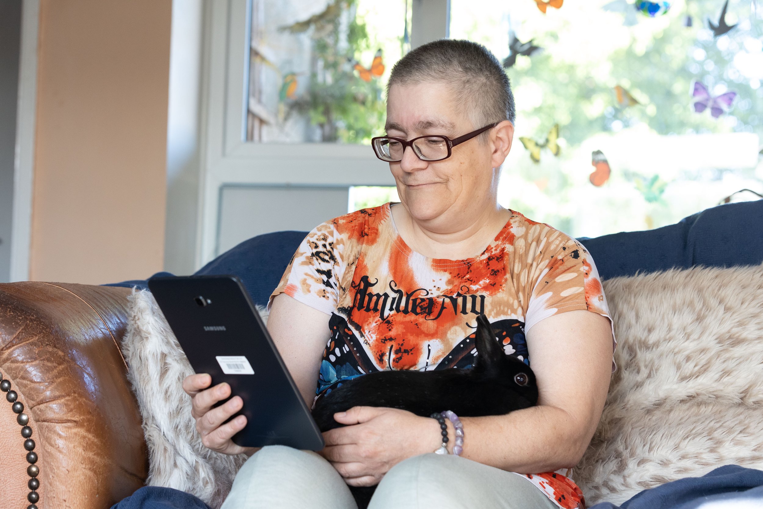 woman looking at phone with pet rabbit
