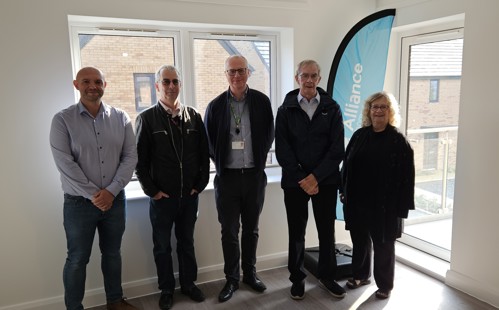 Councillors and Alliance's Chief Operating Officer stand in front of a window