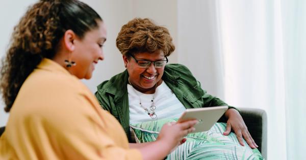 two woman looking at a tablet