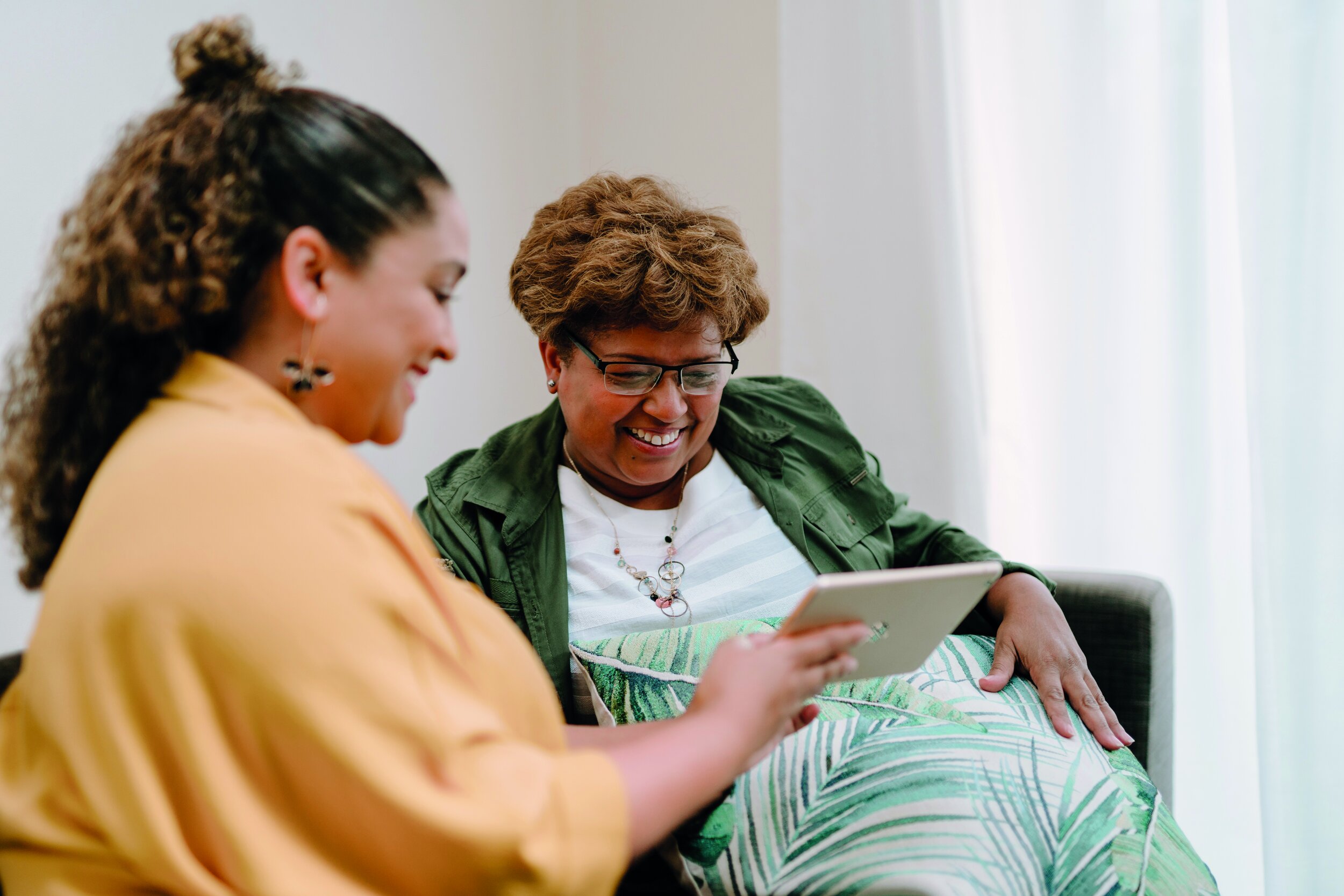 two woman looking at a tablet