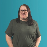 Hannah, Customer Feedback Panel member, wearing a grey top, glasses and standing against a teal backdrop.